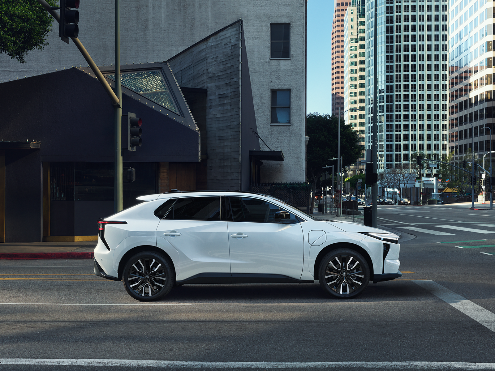 Side view of a white Toyota bZ electric SUV in a city