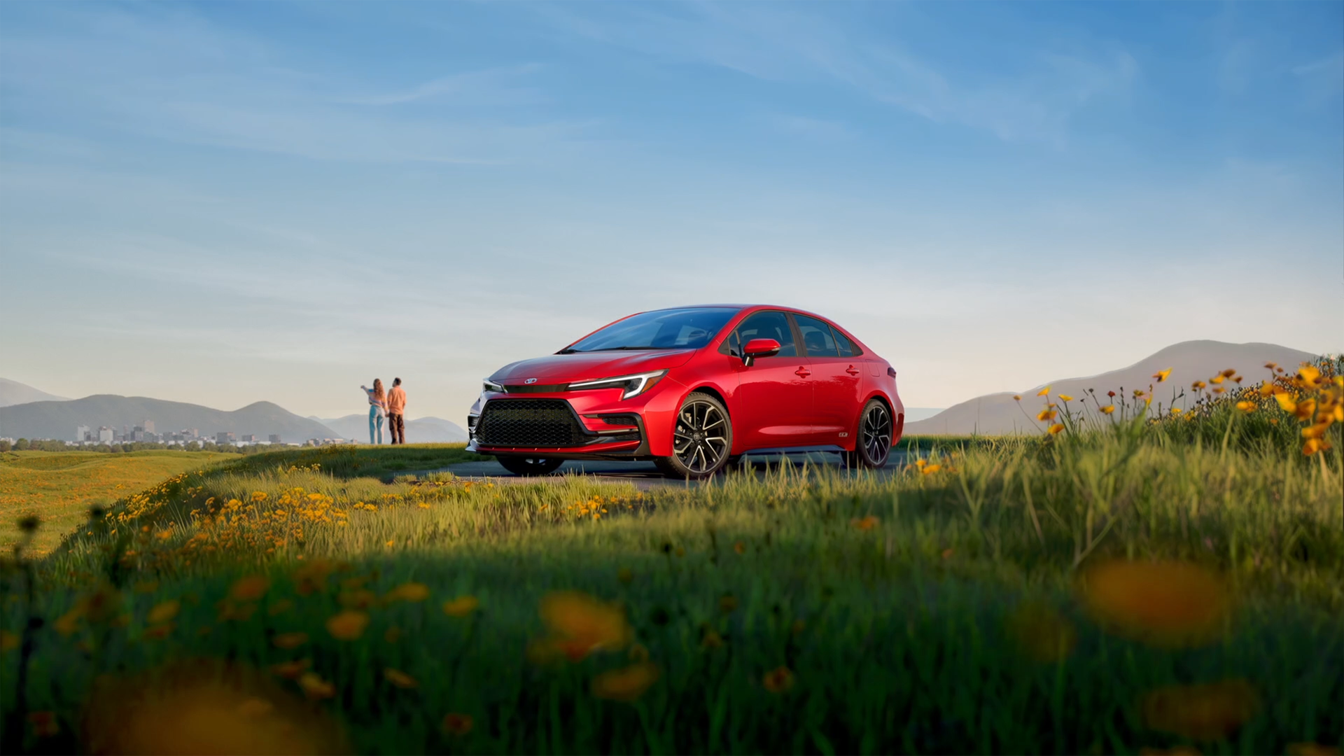 Red 2027 Toyota Corolla sedan parked in a field of wildflowers