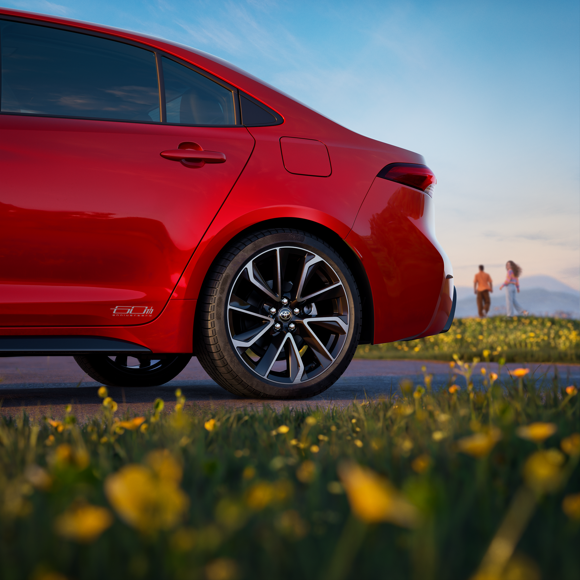 Side detail of a red Toyota Corolla sedan and its alloy wheel